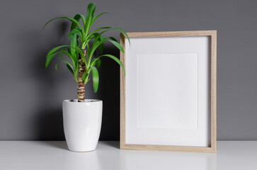 Wooden picture frame mockup with green plant in white pot