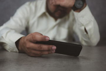 Upset young man at home frustrated by negative message on smartphone gadget, unhappy male distressed by eviction notice email or bad news on cellphone