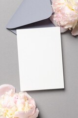 Blank invitation card mockup with envelope and pink peony flowers, mockup with copy space