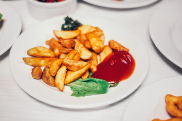 rustic potatoes with sauce and other dishes on the table