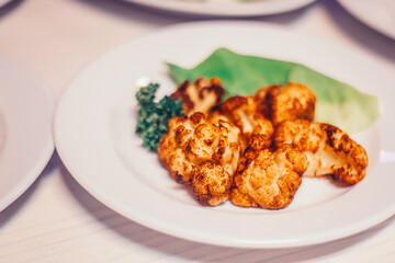 fried cauliflower in breadcrumbs on a white plate
