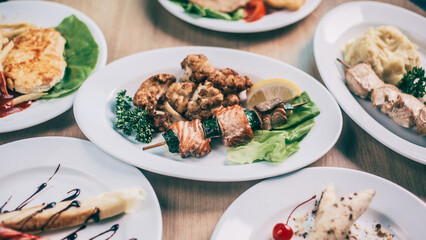 kebab on a wooden skewer and other dishes for a family dinner in the restaurant