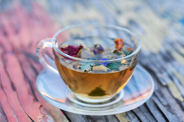 Cup with herbal tea on wooden cracked colored background.
