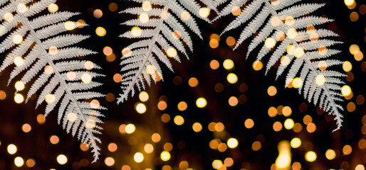 Silver decorative branches on a black background.
and golden bokeh