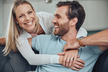 Portrait, love and couple relax on a sofa, embrace and smile while bonding in their home together. Face, man and woman hug, happy and enjoy quality time, relationship and fun in their living room