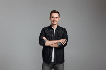 smiling young guy posing with crossed arms