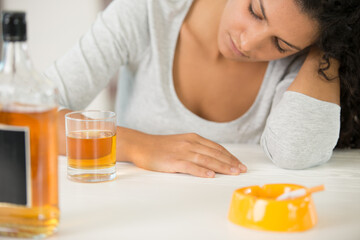 cigarettes with alcohol drinks on wooden table social issues