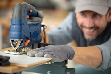 a young male carpenter builder equals a wooden plank