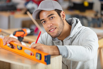 a young male carpenter builder in the workshop