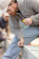 builder checking brick wall with spirit level
