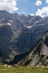 Famous Gavarnie Falls in French Pyrenees, the highest waterfall in mainland France. View from Plateau de Bellevue, with green meadows in foreground.