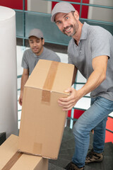 young couriers standing with parcels in stairs indoors