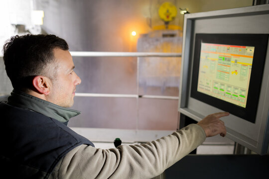 engineer operating machinery on computer touchscreen monitor