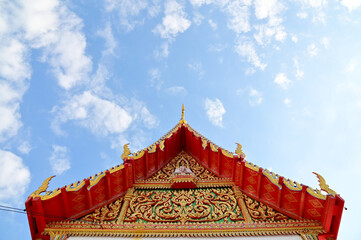 BANGKOK, THAILAND - December 20, 2022 : Part of the Roof of a temple in Thailand. Traditional Thai style pattern on the roof of a temple with Blue Sky Background.