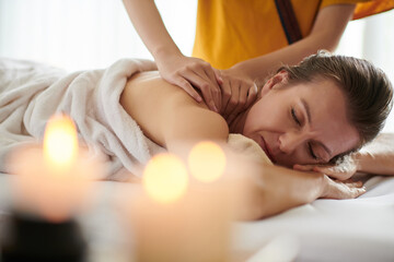 Obraz na płótnie Canvas Mature woman getting relaxing shoulder massage in spa salon