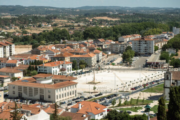 Fototapeta na wymiar Tomar, Portugal, 17 August 2022. Empty square Largo da Varzea Grande with in the middle visible column and TOMAR inscription or Letras de Tomar,District Court of Tomar,central bus station