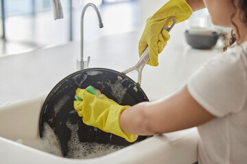 Cleaning pan, washing and hygiene hands with soap and water in the kitchen sink in home. Zoom of a...