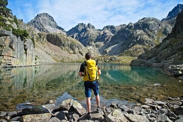 Man facing away contemplates the Ibones de Arriel and surrounding peaks in the Spanish Pyrenees,