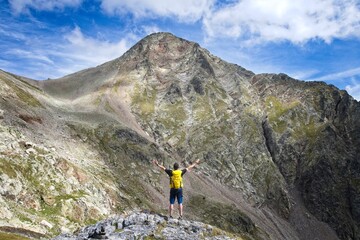 Man looking away reaches out to Arriel peak in the Valle de Tena, the Spanish Pyrenees