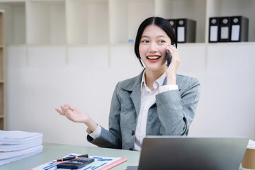 Asian business woman using mobile phone in office.