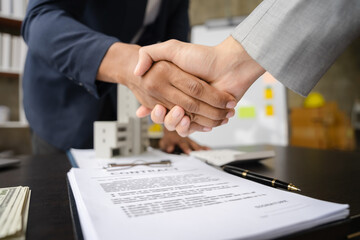 Close up shake hands, Considering buying a home, investing in real estate. Broker signs a sales agreement. agent, lease agreement, successful deal.