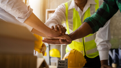 Team architects workers, men and women, join hands to join forces to join forces to work for the...