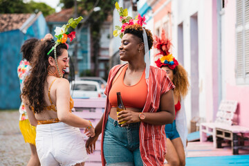 Woman dancing in the street during Carnival Festival. Friends enjoying brazilian carnival in the summer.