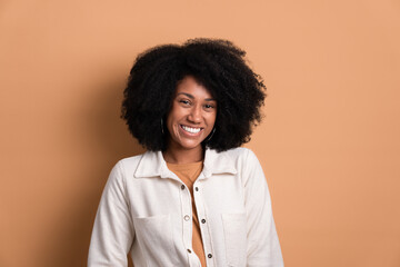 shy afro brazilian woman smiling wearing white jacket in studio shot. portrait, real people concept.