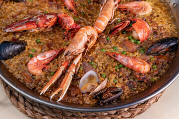 Paella marinera with shrimps and mussels close-up in a frying pan