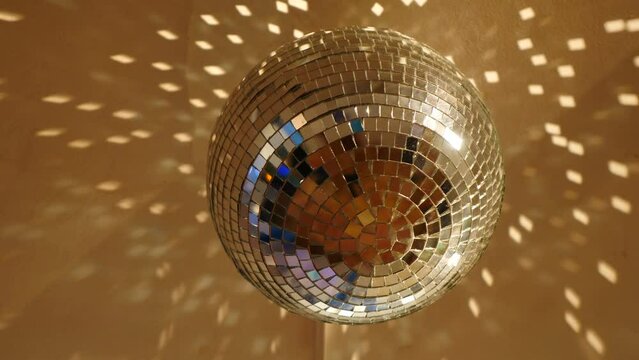 Bright large retro silver disco ball rotating close up. Rotating disco mirror ball. Sparkling disco balls spinning with flashing lights during music band performance or dancing party. 4 k video