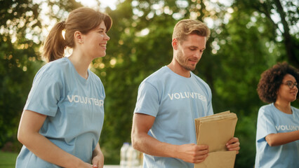 Naklejka premium Positive Group of Volunteers Preparing Humanitarian Aid and Donations, Loading Boxes in a Cargo Van. Charity Workers Help Members of the Community. Free Meals to Unemployed, Refugees and Immigrants.