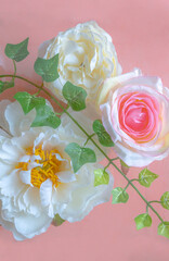 Vertical image of soft decor flowers on the pink background. Muted soft colours