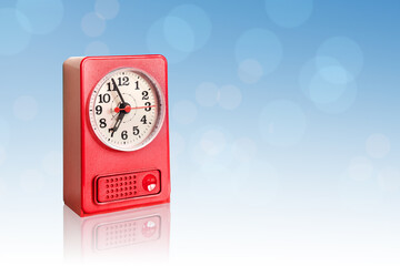 red retro clock on blue bokeh background