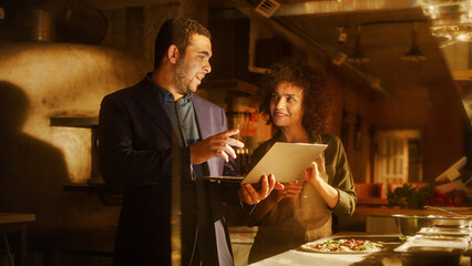 Restaurant Small Business Owners: Happy Male and Female Business Partners Use Laptop Computer, Discuss Growth Strategy. Two Entrepreneurs Working on Optimization of Online e-Business Orders in Shop
