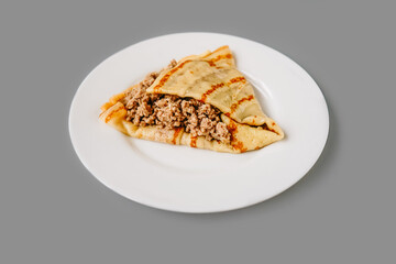 Person eating crepes with filling. Tasty breakfast.