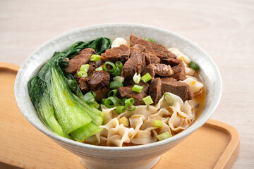 Beef noodle soup. Taiwanese famous food in a bowl on wooden table.