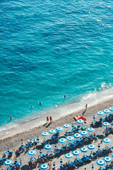 Blue beach umbrellas and the beautiful shoreline of the beach at Positano on the Amalfi Coast.
