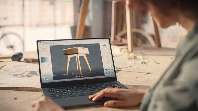 Woodcraft Artist Working on Laptop Computer, Creating a Digital 3D Model of a Stylish Wooden Bedside Table. Creative Multiethnic Female Preparing a Design for Carpentry Project on a Screen.