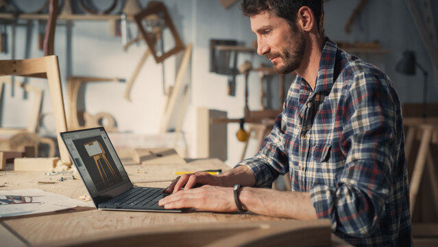 Handsome Furniture Designer Working on Laptop Computer, Creating a Digital 3D Model of a Stylish Wooden Bedside Table. Creative Young Man Preparing a Design for Carpentry Project.