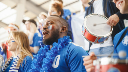 Sport Stadium Big Event: Handsome Black Man Cheering. Crowd of Fans with Painted Faces Shout for...
