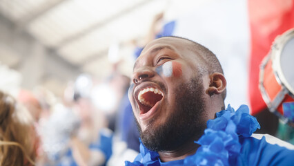 Sport Stadium Event: Handsome Black Man with French Flag Painted on Face Cheering for His Team to...