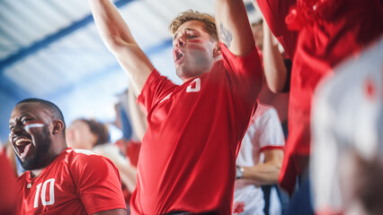 Fototapeta premium Sport Stadium Sport Event: Intense Caucasian Man Cheering, Whistling. Crowd of Fans with Painted Faces Stand up, Cheer, Shout for Red Soccer Team to Win, Celebrate Scoring Goal, Championship Victory