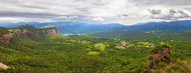Great aerial panoramic view of Las Guillerias with the Sau reservoir, the Collsacabra cliffs, and Vilanova de Sau. Guilleries Natural Park, Catalonia, Spain
