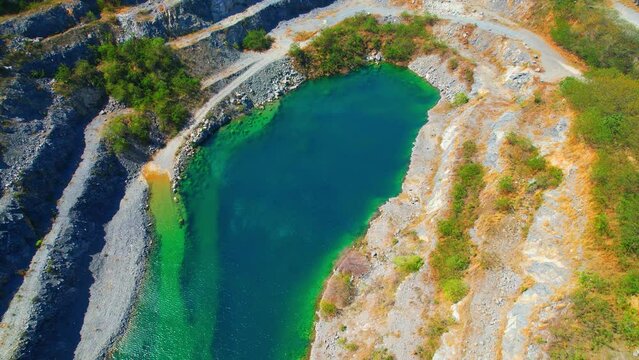 Drone flying over a quarry in the tropical, large commercial industry for infrastructure. pollution problems from dust respiratory tract and environmental problems concept. Aerial view footage. 4K
