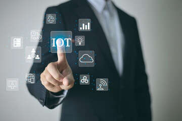 Internet of Things or IOT technology concept. businessman hand touch IOT virtual screen interface. with icons of shopping cart, banking, cloud computing, server network system, chip, email, multimedia