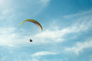 Paraglider flying among epic sky on a sunny day