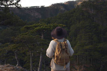 Girl traveler walks through the forest and enjoys the fresh air.