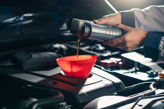 the technician maintained and refilled the lubricant for the car's engine in the garage. the concept of engineering, transportation, petroleum and automobiles