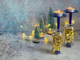 Champagne glasses, decoratively decorated to prepare for the New Year with candles.Postcard with copy space. The use of bokeh