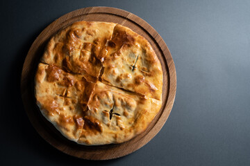 top view of traditional georgian bread khachapuri with filling on wooden board